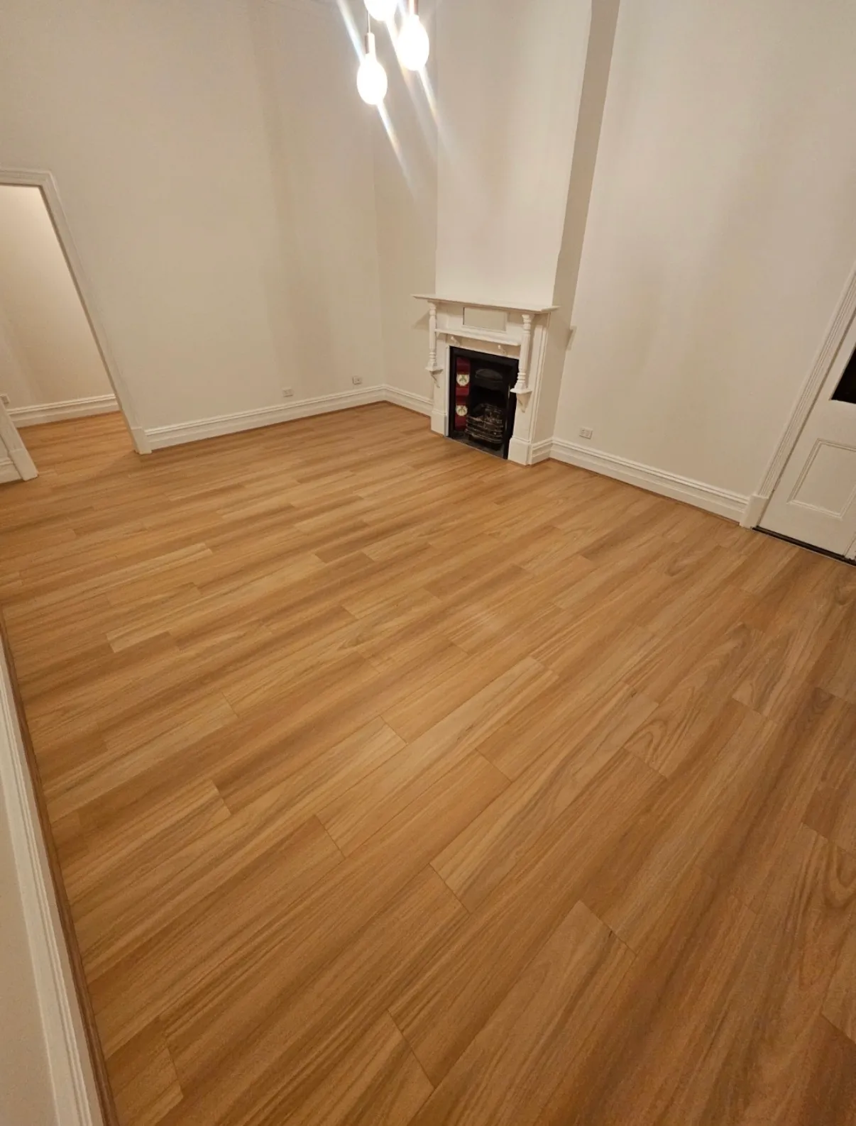 Laminate flooring laid through a character home with an original fireplace